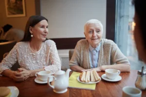 Home carer sharing afternoon tea with an older woman during 24-hour home care in London