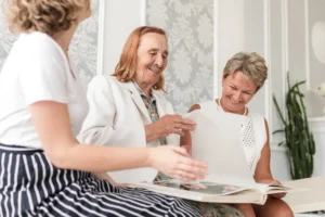 Three generations of a family look through a photo album at home while planning dementia care in London