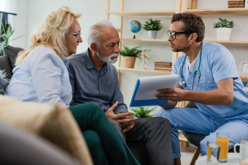 Home care professional explaining funding documents to an older couple in their London home